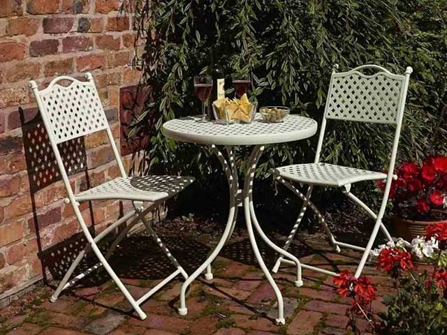 Sage green metal table and chairs set for two on the patio - 2021 garden furniture - Goodhomesmagazine.com