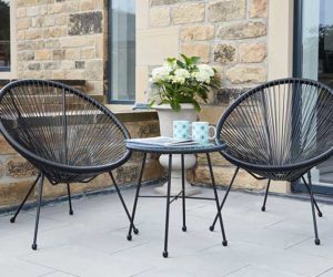 A modern patio garden with two matching black egg chairs and a coffee table with two mugs on it - 2021 garden furniture - Goodhomesmagazine.com