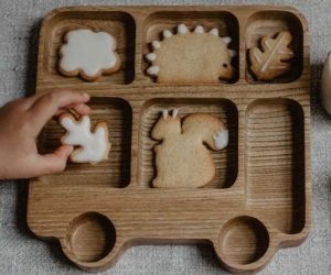 A children's oak dinner tray in the shape of a bus with biscuits in different segments - Sustainable kitchen swaps - Goodhomesmagazine.com
