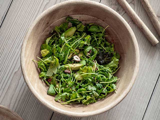 Natural bamboo bowl filled with a green salad - BBQ week essentials - Goodhomesmagazine.com