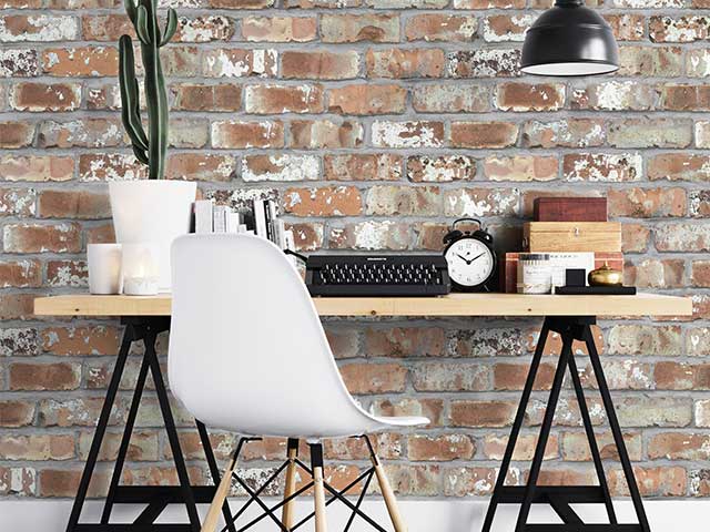 Red brick effect wallpaper on a wall behind a desk - Instagram wallpaper trends - Goodhomesmagazine.com