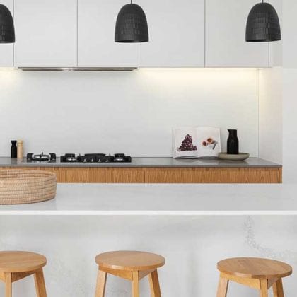 Modern kitchen with a white island and four wooden stools - Tiktok kitchen trends - Goodhomesmagazine.com