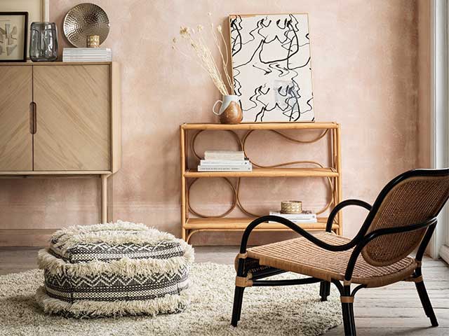 Rattan chair in a neutral room with a fluffy footstall and a rattan shelving unit - Rattan - Goodhomesmagazine.com