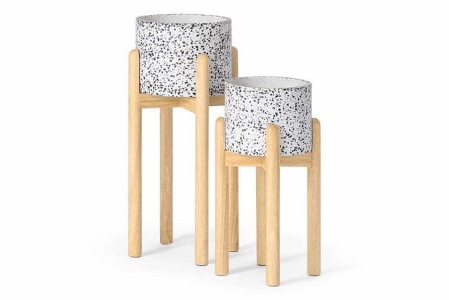 Two different sized terrazzo plant pots on wooden stands - Tile decor trends - Goodhomesmagazine.com