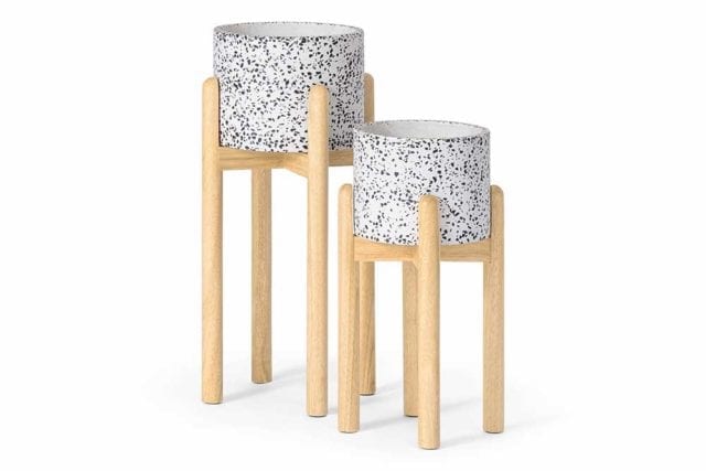 Two different sized terrazzo plant pots on wooden stands - Tile decor trends - Goodhomesmagazine.com