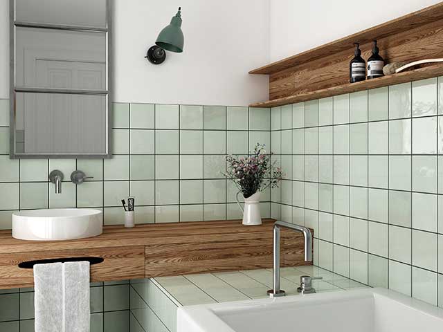 A bathroom with mint wall tiles and wooden shelving - Earthy tones - Goodhomesmagazine.com