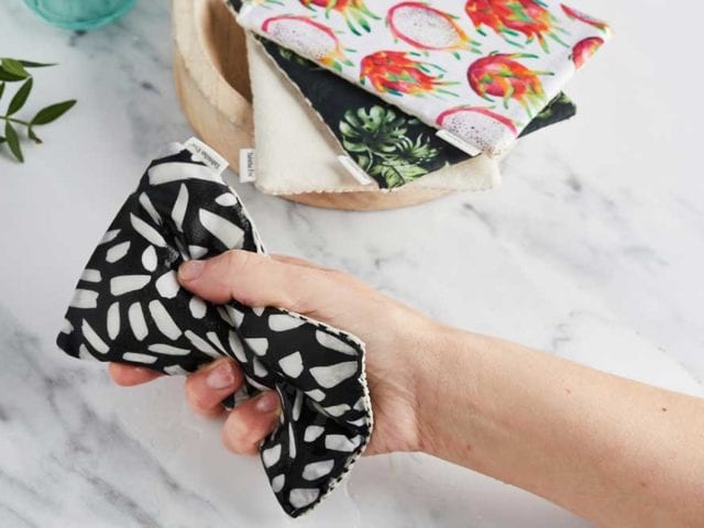 A hand holding a black and white patterned sponge - Sustainable kitchen swaps - Godhomesmagazine.com