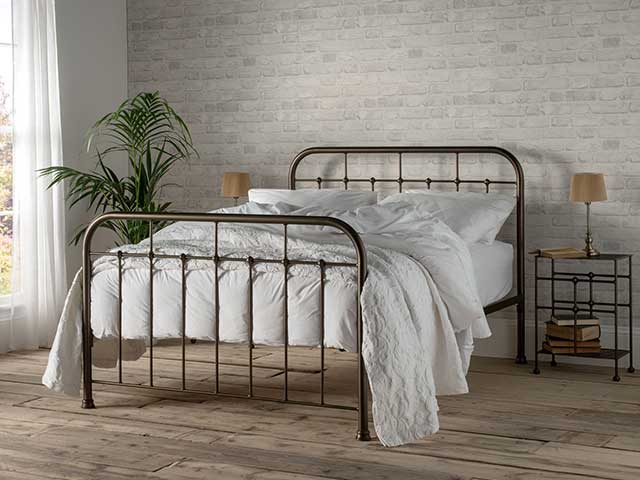 Dormitory-style curved iron bronze bed frame in a bedroom - Iron beds - Goodhomesmagazine.com