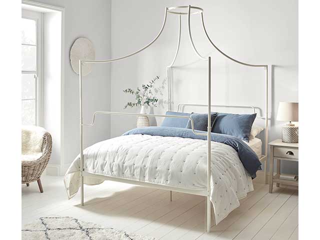 White iron canopy-style bed frame in a bedroom - Iron beds - Goodhomesmagazine.com