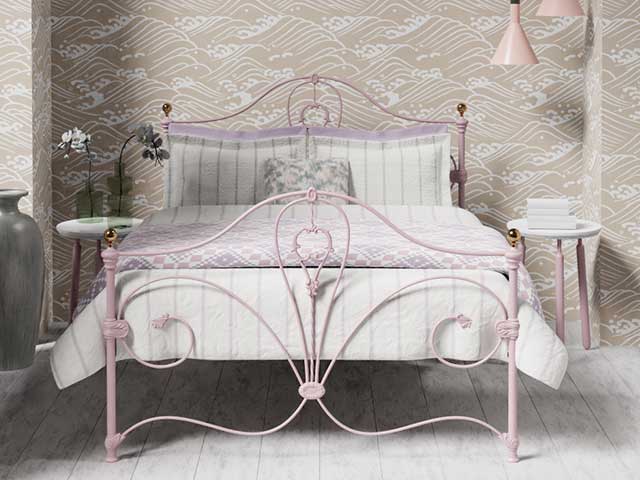 Pink ornate iron bed frame in a bedroom - Iron beds - Goodhomesmagazine.com