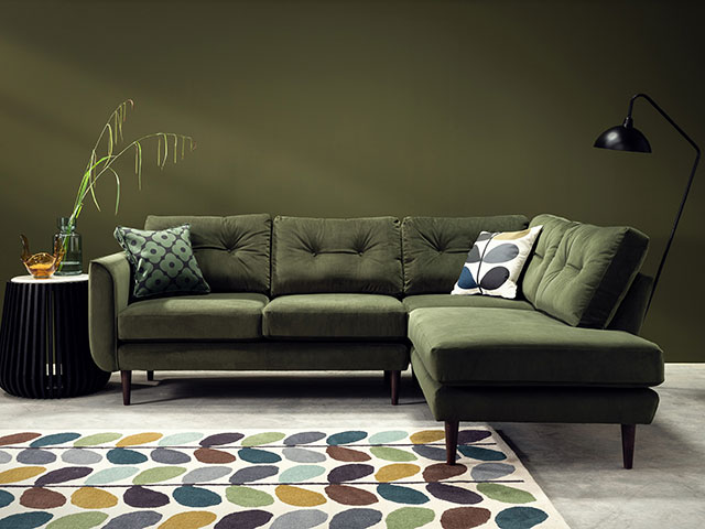 Pincushion green corner sofa with teal, green rug 