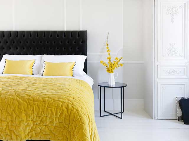 Charcoal bed with a bright yellow throw and cushions - Grey bedrooms - Goodhomesmagazine.com