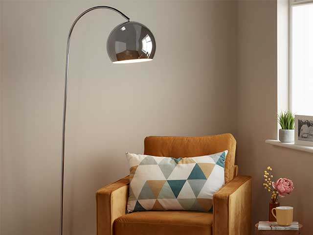 Dome arc-shaped floor lamp next to a mustard armchair - Living room lighting - Goodhomesmagazine.com