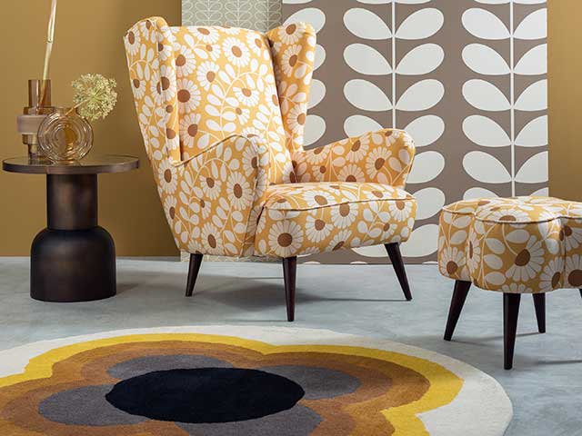Floral vibrant arm chair with tall back, footstool and seventies style rug in flower shape