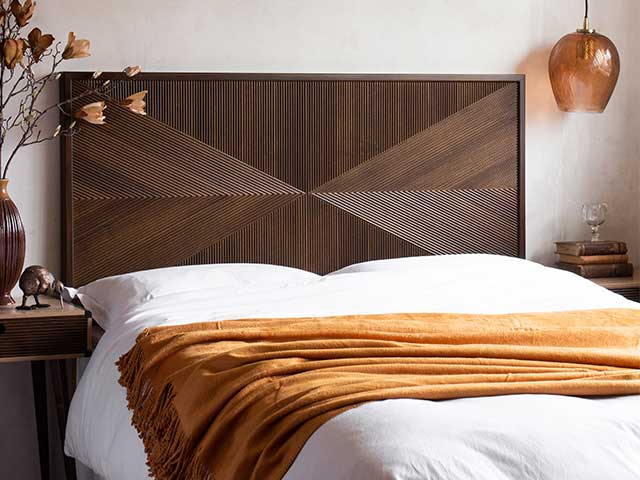 Bed with a dark wooden headboard - Goodhomesmagazine.com