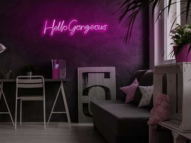 'Hello Gorgeous' cursive neon light on a wall with a sofa and desk in it - neon lights - Goodhomesmagazine.com