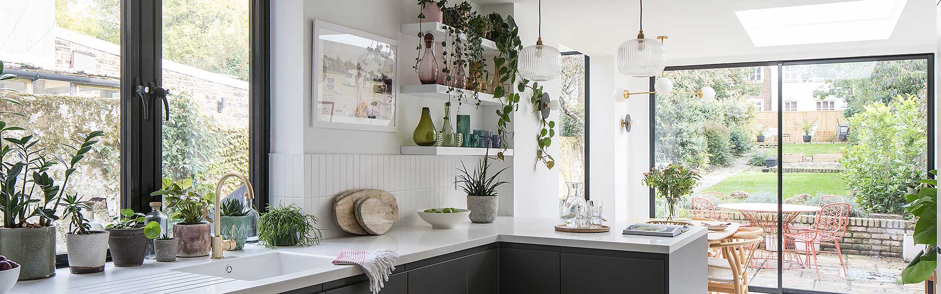Melbourne-inspired home kitchen with plant life, full length doors and windows onto substantial garden