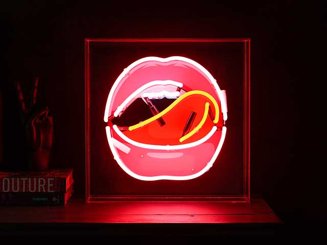 Neon lightbox with an open mouth with tongue licking top lip - neon lights - Goodhomesmagazine.com