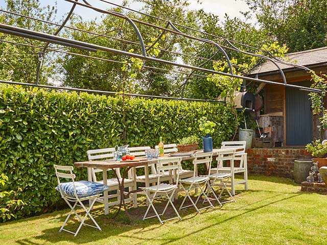 Al fresco dining set up with metal chairs and grass