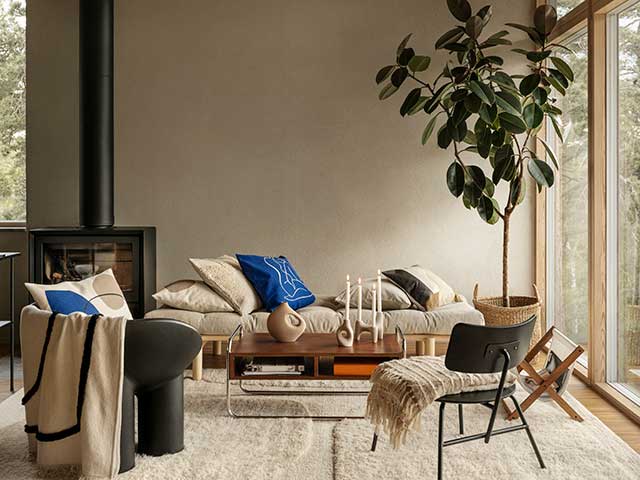 Living room space with neutral throws, rug, wall and blue scatter cushions