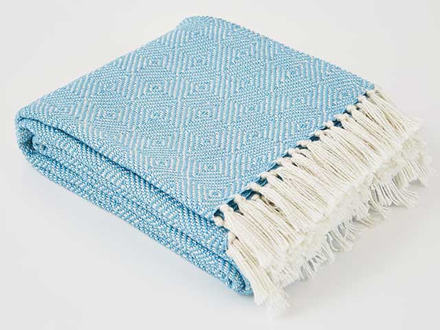 Sky blue sustainable blanket made from recycled plastic bottles on white background