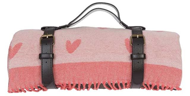 pink wool blanket with hearts and leather strap on white background