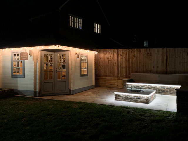 A self-build fire pit area and garden pub at night