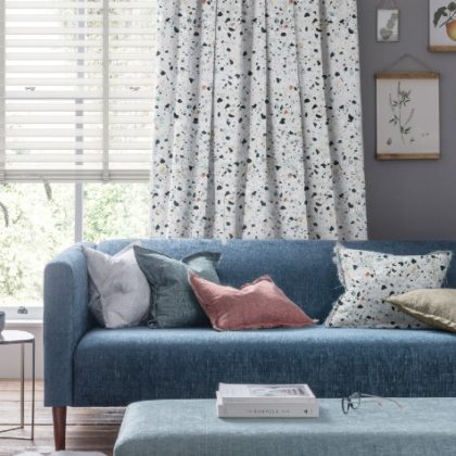 blue sofa with spotty curtains and white blinds