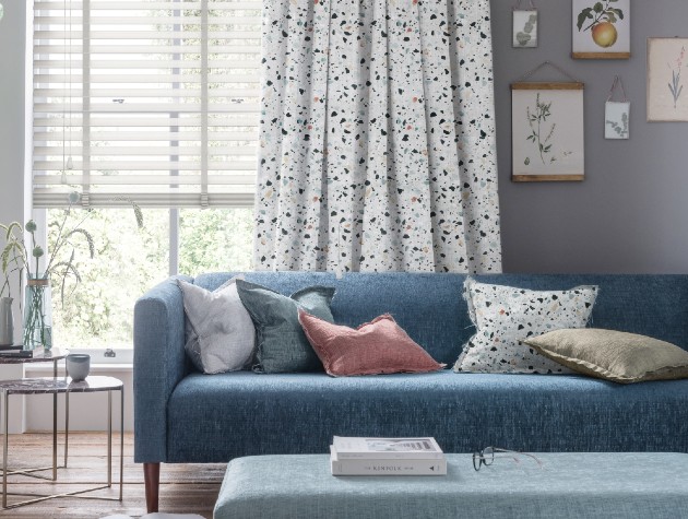 blue sofa with spotty curtains and white blinds