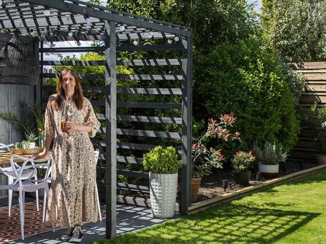 Karen standing in outdoor zoned garden makeover in front of Pergola and plants