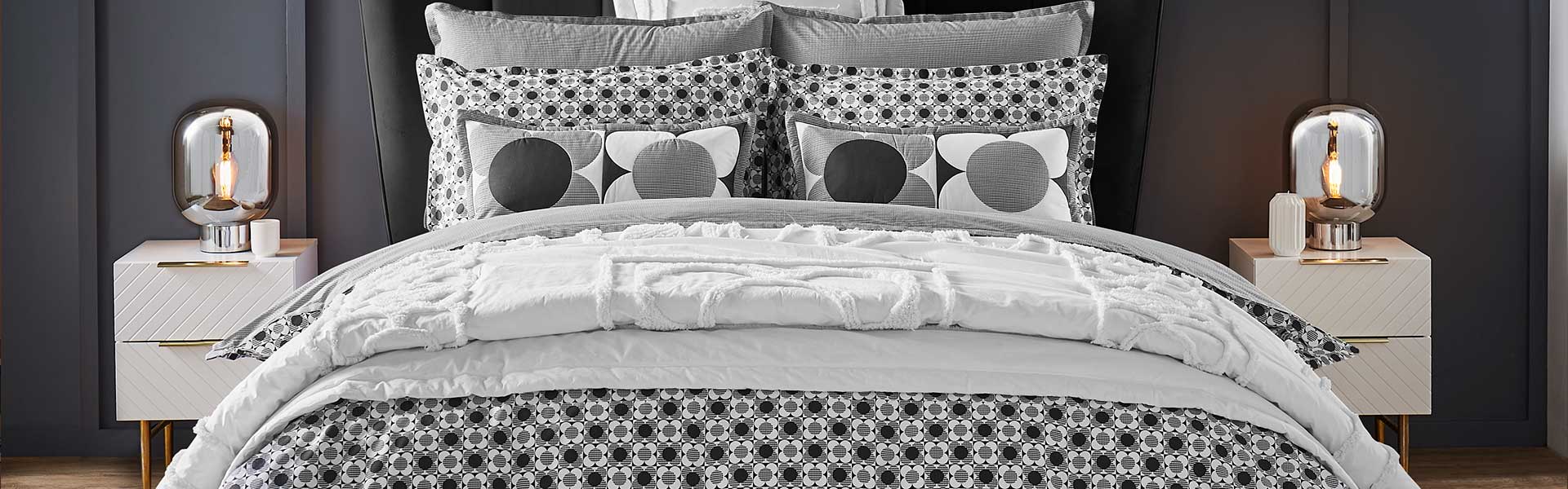 Monochrome bedding on double bed with scatter cushions