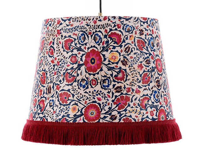 Floral lampshade with red trim on white background