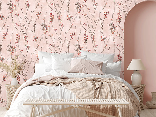 Pink floral decor wallpaper in bedroom with messy bed and archway
