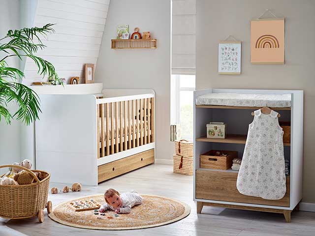 Wooden cot, rattan basket and floral rug in Laura Ashley nursery collection