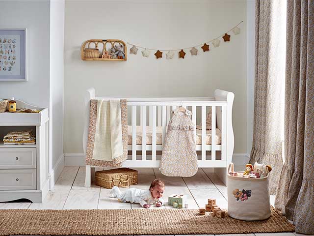 Gender neutral nursery in beige, cream and brown with white flooring and cot
