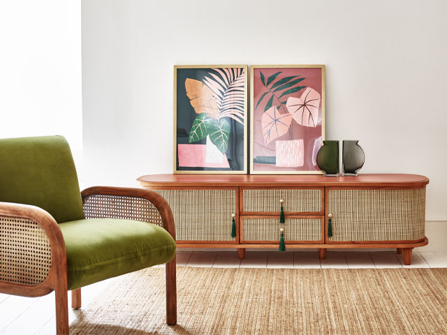 Oliver Bonas rattan sideboard with rattan armchair, seagrass rug and palm print wallart