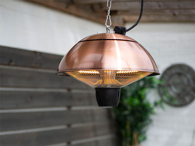 Electric outdoor heater in copper hanging from a garden pergola 
