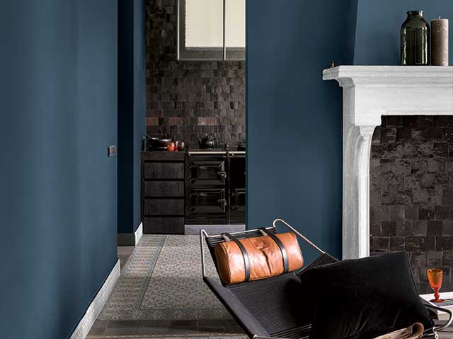 White fireplace in navy living room with wooden floor