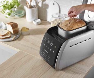Bread makers on work top with fresh loaf in container 