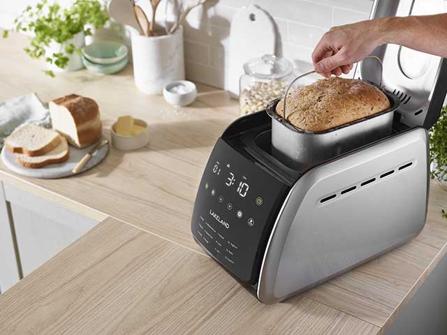 Bread makers on work top with fresh loaf in container 