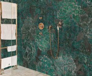 Green tropical print bathroom wallpaper in walk-in shower with gold fittings