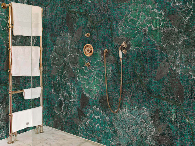 Green tropical print bathroom wallpaper in walk-in shower with gold fittings