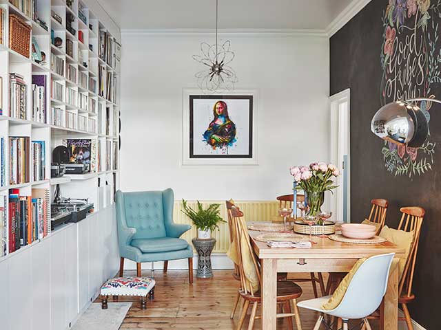 Dining room with blackboard wall and good vibes only artwork with bespoke bookshelf on opposite wall