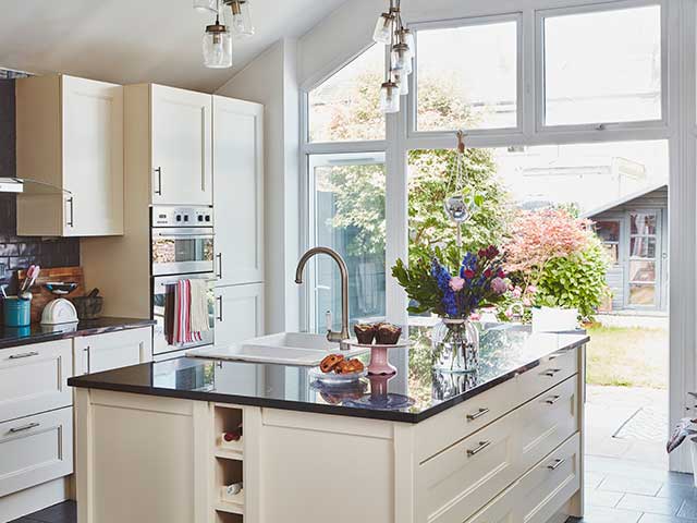 Kitchen island with cream units and drawers opening out to back garden