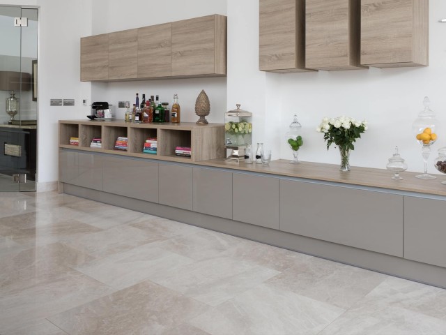 Contemporary open-plan space with handleless units running down one length of the living room wall