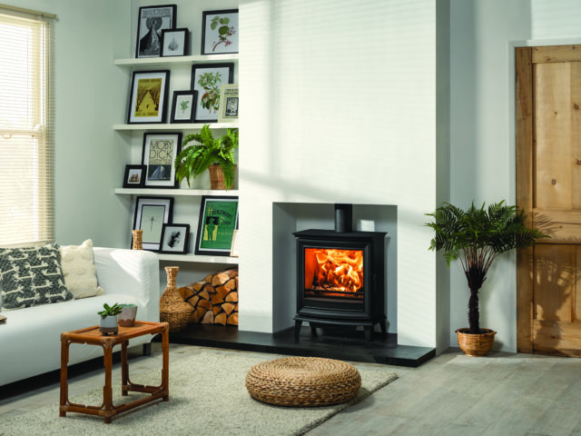 refurbished cottage with white walls, picture shelves in the alcove and log burner