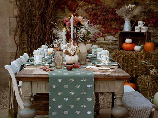 Halloween decor tablescaping with candles, flowers and pumpkins