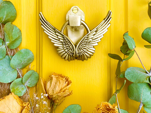 doorscaping angel wing door knocker on a yellow door