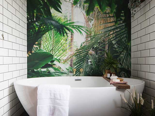 large oval bathtub in front of tropical bathroom wallpaper