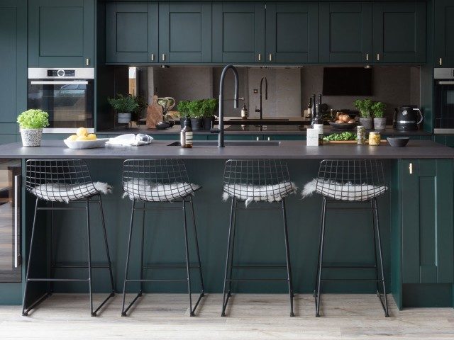 dark green kitchen cabinets with breakfast bar an bar stools